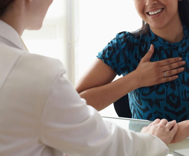 Woman smiling while having a discussion with her doctor.